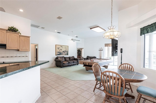 dining area with ceiling fan, pool table, a high ceiling, and light tile patterned floors