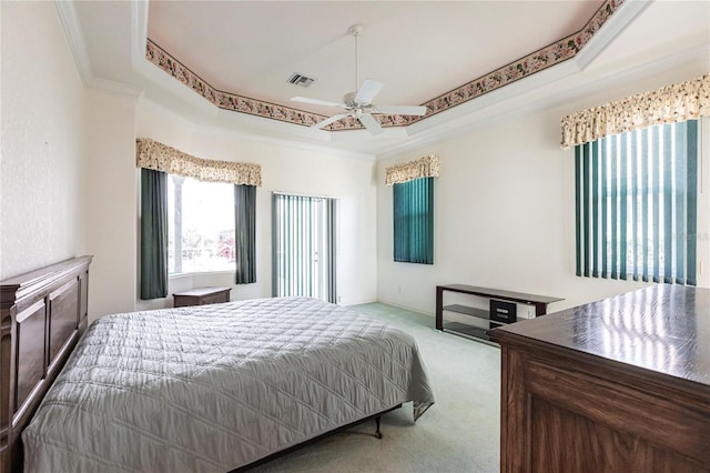 carpeted bedroom featuring crown molding, a raised ceiling, and ceiling fan