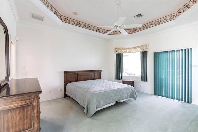 carpeted bedroom with ceiling fan, ornamental molding, and a tray ceiling