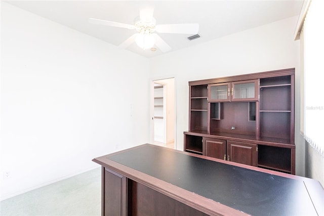 unfurnished office with ceiling fan and light colored carpet