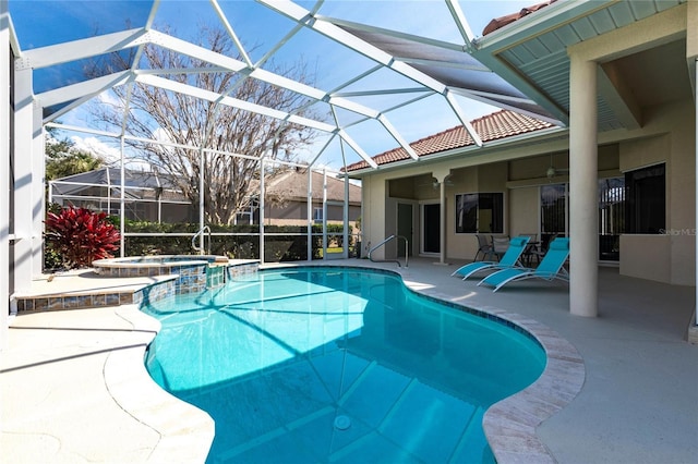 view of pool with an in ground hot tub, ceiling fan, glass enclosure, and a patio