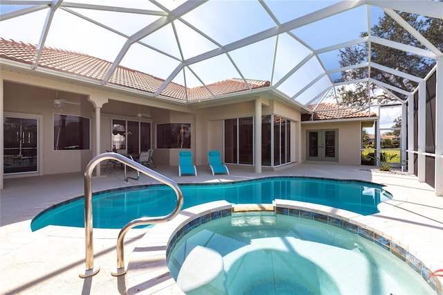 view of swimming pool featuring french doors, an in ground hot tub, ceiling fan, and glass enclosure