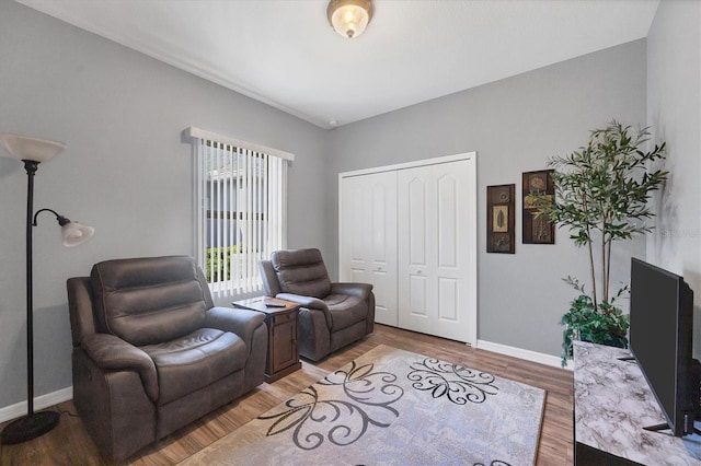 living room featuring wood-type flooring and vaulted ceiling