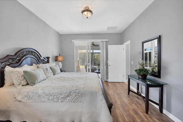 bedroom with access to outside and wood-type flooring