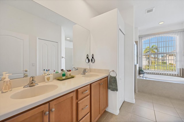 bathroom with vanity, tiled tub, and tile patterned flooring