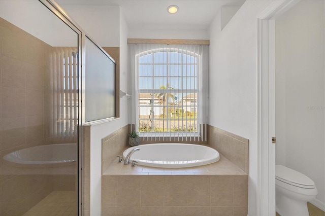 bathroom featuring shower with separate bathtub, toilet, and a healthy amount of sunlight