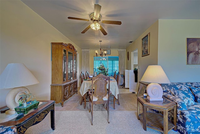 tiled dining area with ceiling fan with notable chandelier