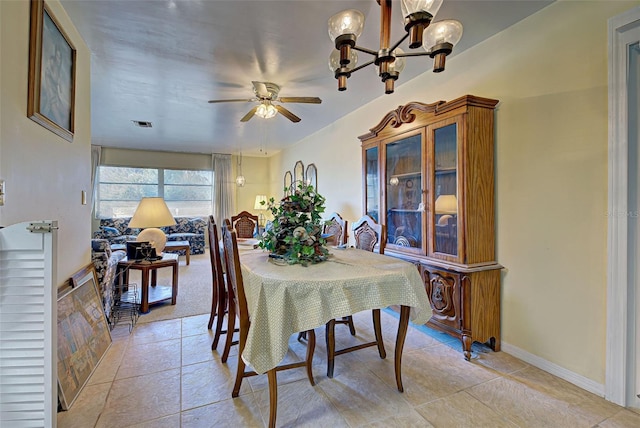 dining room with ceiling fan with notable chandelier and light tile patterned floors