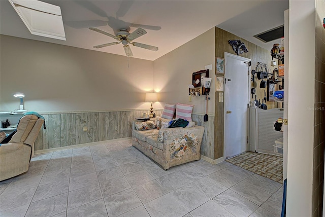 unfurnished room with ceiling fan, light tile patterned floors, and wooden walls