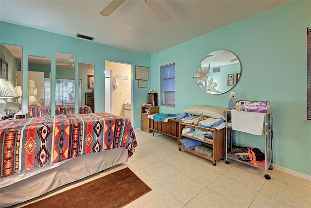 tiled bedroom featuring connected bathroom and ceiling fan