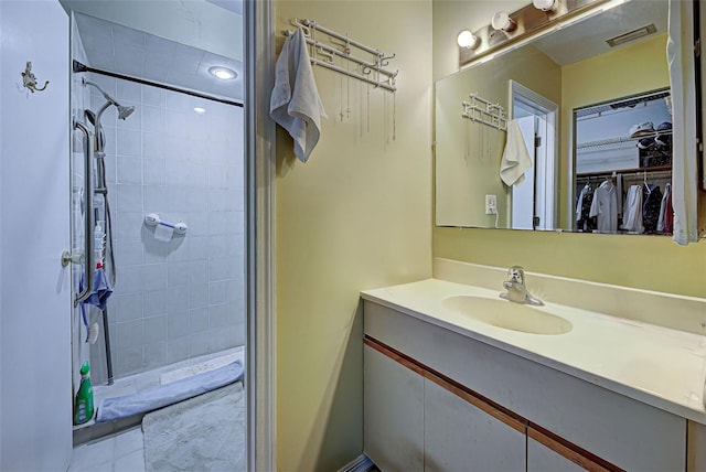 bathroom featuring vanity and tiled shower