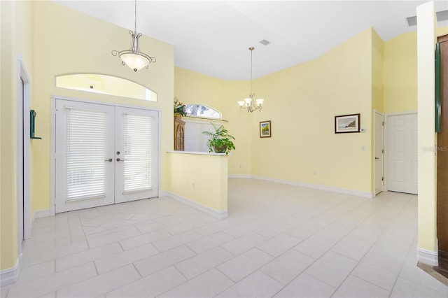 foyer featuring french doors, light tile patterned floors, an inviting chandelier, and high vaulted ceiling