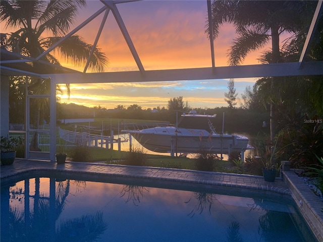 pool at dusk featuring glass enclosure