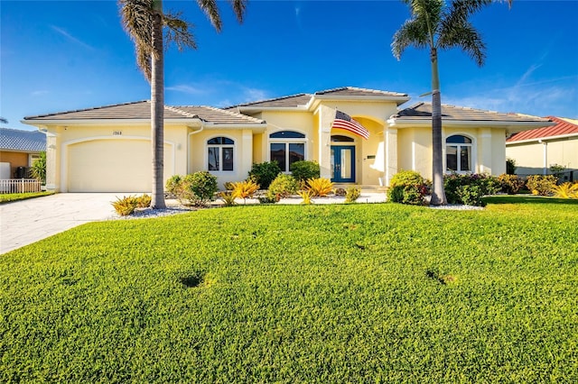 mediterranean / spanish-style house featuring a front yard and a garage