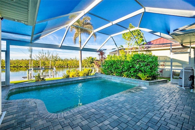 view of pool with glass enclosure, a patio area, a water view, and a dock