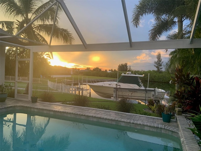 pool at dusk with glass enclosure and a dock