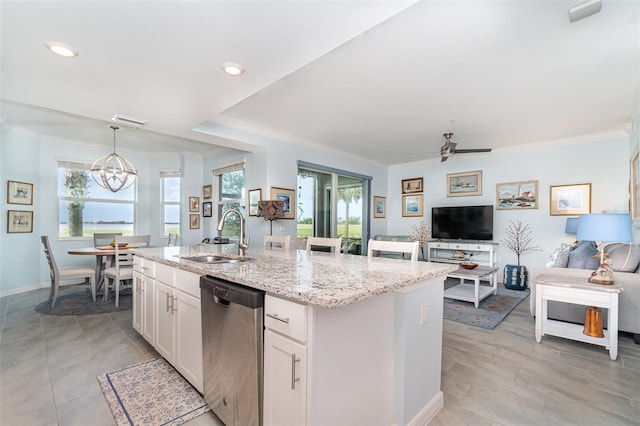 kitchen featuring sink, white cabinetry, decorative light fixtures, stainless steel dishwasher, and a center island with sink