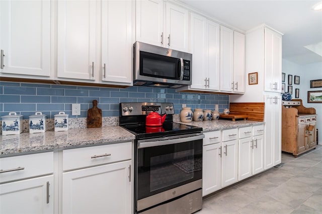 kitchen featuring backsplash, appliances with stainless steel finishes, light stone counters, and white cabinets