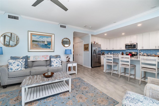 living room featuring light hardwood / wood-style flooring, crown molding, and ceiling fan