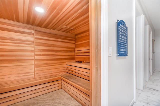 view of sauna with wood ceiling and wooden walls