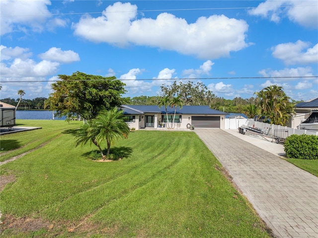 ranch-style house featuring a water view, a front lawn, and a garage