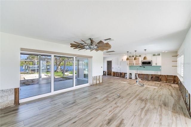 unfurnished living room featuring light hardwood / wood-style floors and ceiling fan