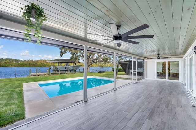 view of pool featuring a patio area, a yard, a water view, and ceiling fan