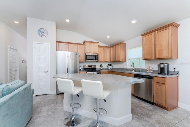 kitchen featuring appliances with stainless steel finishes, light tile patterned floors, vaulted ceiling, and a kitchen island