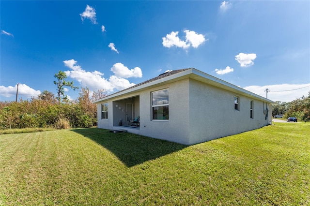 back of property featuring a lawn