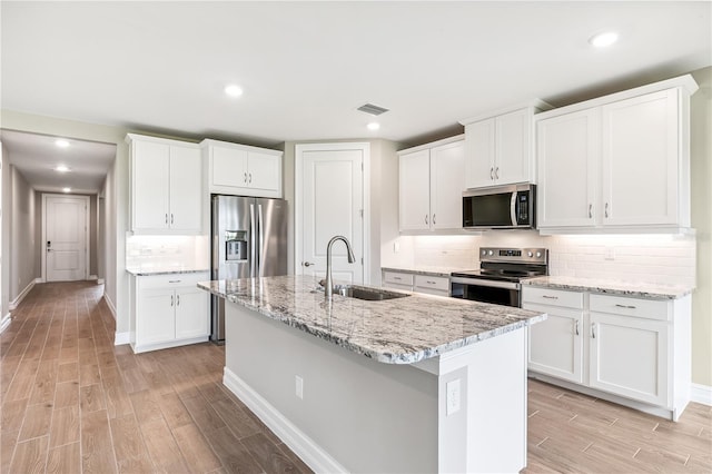 25236 Rampart Blvd, Punta Gorda, FL 33983 - kitchen featuring stainless steel appliances, light wood-type flooring, a center island with sink, backsplash, and recessed lighting