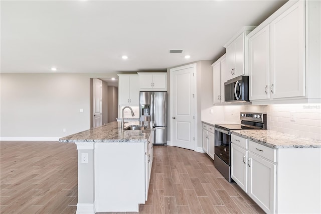 25236 Rampart Blvd, Punta Gorda, FL 33983 - kitchen featuring appliances with stainless steel finishes, light wood-type flooring, white cabinets, tasteful backsplash, and recessed lighting