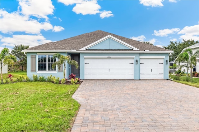 25236 Rampart Blvd, Punta Gorda, FL 33983 - ranch-style home with stucco siding, a front yard, decorative driveway, an attached garage, and a shingled roof
