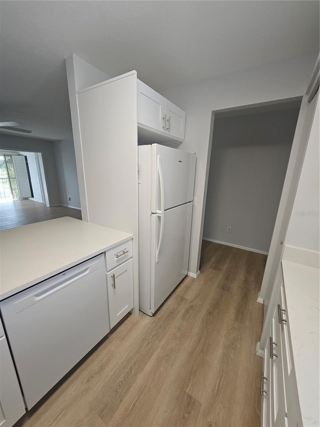 kitchen with white cabinetry, light hardwood / wood-style flooring, and white appliances