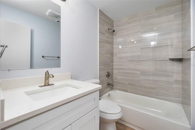 full bathroom with vanity, toilet, hardwood / wood-style floors, and tiled shower / bath