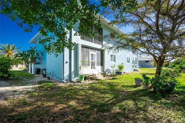 view of property exterior featuring a lawn and a balcony