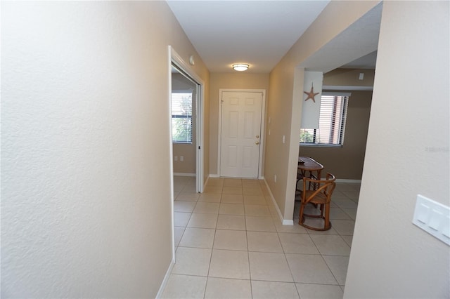 hallway featuring a healthy amount of sunlight and light tile patterned flooring