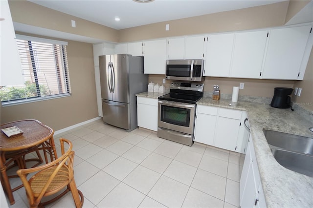 kitchen featuring sink, appliances with stainless steel finishes, white cabinetry, and light tile patterned floors