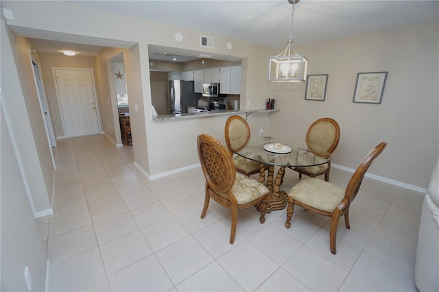 tiled dining area featuring a chandelier