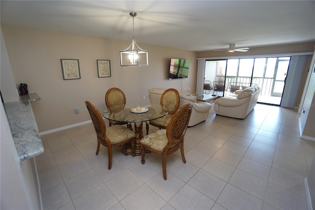 tiled dining room with ceiling fan with notable chandelier