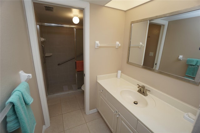 bathroom featuring vanity, a shower with shower door, toilet, and tile patterned floors