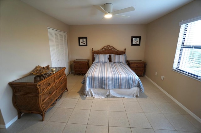 bedroom with a closet, light tile patterned floors, and ceiling fan