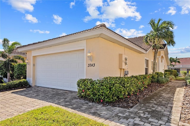 3743 Albacete Cir Unit 84, Punta Gorda, FL 33950 - view of side of property with stucco siding, decorative driveway, and a tile roof