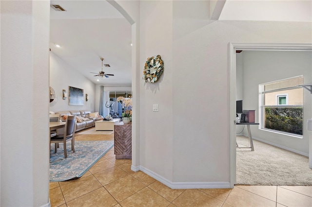 hallway with light tile patterned floors and lofted ceiling