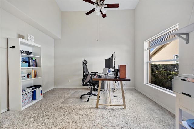 carpeted office featuring a high ceiling and ceiling fan