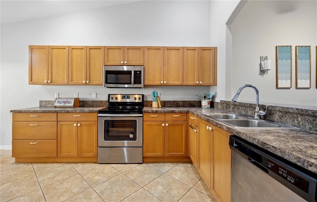 3743 Albacete Cir Unit 84, Punta Gorda, FL 33950 - kitchen featuring stainless steel appliances, a sink, light tile patterned floors, dark countertops, and brown cabinetry