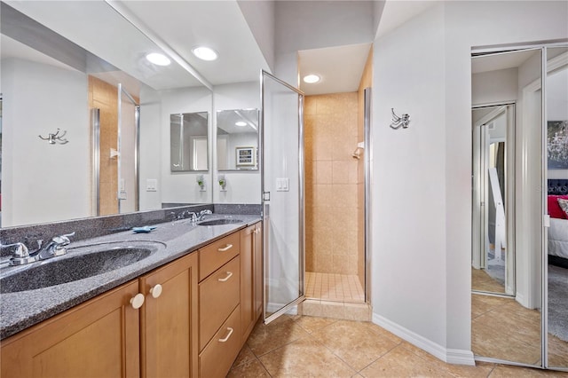 bathroom with vanity, a tile shower, and tile patterned floors