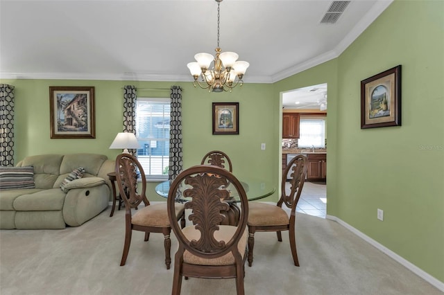 2831 Corinthia Cir, North Fort Myers, FL 33917 - dining space featuring visible vents, crown molding, baseboards, a chandelier, and light carpet