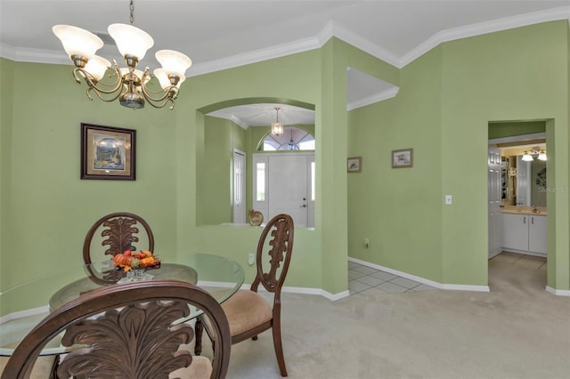 dining room featuring an inviting chandelier, ornamental molding, and light colored carpet