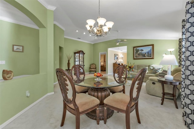 carpeted dining area with ornamental molding, vaulted ceiling, and ceiling fan with notable chandelier