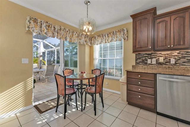 dining area featuring ornamental molding, light tile patterned flooring, and an inviting chandelier